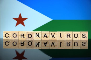 WROCLAW, POLAND - 28 Mart 2020: söz CORONAVIRUS ahşap harflerden yapılmış, ve arka planda Cibuti Bayrağı. Coronavirus (COVID-19) küresel hastalık 2020.