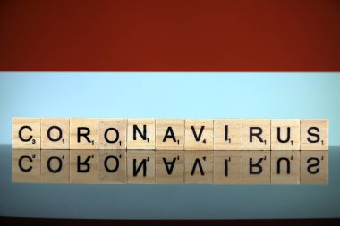 WROCLAW, POLAND - 28 Mart 2020: söz CORONAVIRUS ahşap harflerden yapılmış, ve arkada Endonezya Bayrağı. Coronavirus (COVID-19) küresel hastalık 2020.