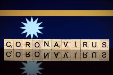 WROCLAW, POLAND - 28 Mart 2020: söz CORONAVIRUS ahşap harflerden yapılmış, ve arka planda Nauru Bayrağı. Coronavirus (COVID-19) küresel hastalık 2020.