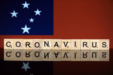 WROCLAW, POLAND - 28 Mart 2020: söz CORONAVIRUS ahşap harflerden yapılmış, ve arka planda Samoa Bayrağı. Coronavirus (COVID-19) küresel hastalık 2020.