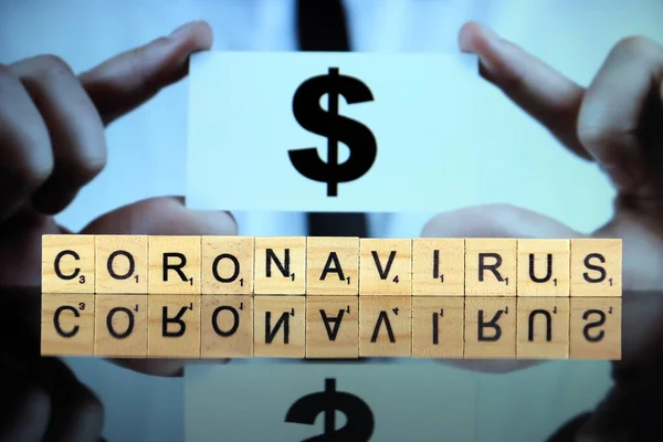 克拉夫特 2020年3月30日 Coronavirus 这个词是由木制信件制成的 而男人则拿着一张印有美元符号的名片作为背景 Coronavirus Covid 2020年全球疾病 — 图库照片