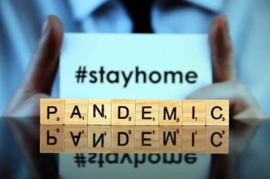 WROCLAW, POLAND - 30 Mart 2020: Ahşap harflerden oluşan PANDEMIC sözcüğü ve arka planda 