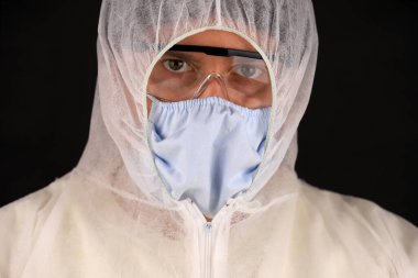 Hızla yayılan koronavirüs sırasında koruyucu kıyafetli ve maskeli bir doktor. Küresel koronavirüs hastalığı (COVID-19) 2020.