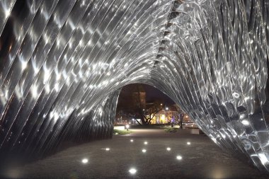 WROCLAW, POLAND - 10 Mart 2020: Daliowa Adası 'nda Oskar Zieta tarafından tasarlanan NAWA heykelinin gece görüşü. Çelik yüzey parlatıldığı için NAWA çevreyi yansıtıyor..