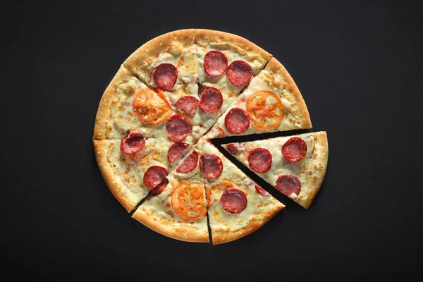Pizza casera con pepperoni, tomate, carbonato, mozzarella sobre fondo de piedra negra — Foto de Stock