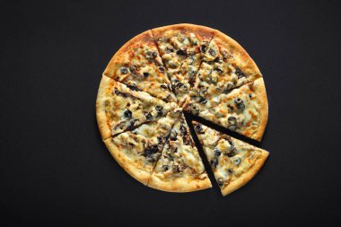 Siyah bir taş zemin üzerine jambon ve petrol zeytinli pizza