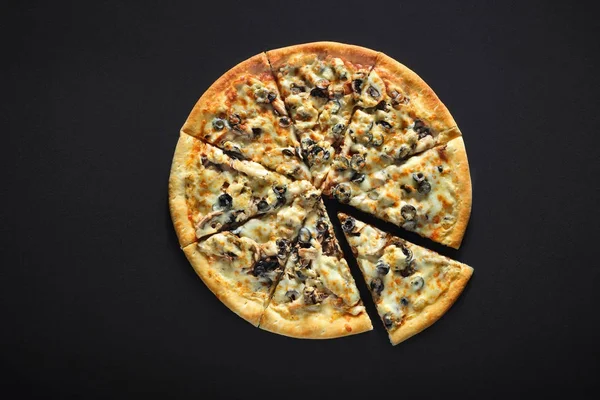 Pizza met ham en champignons olijven op een zwarte achtergrond van de stenen — Stockfoto