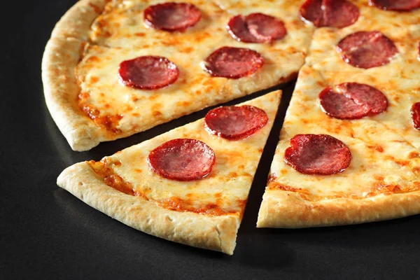 Corte Pizza cerca peperoni sobre fondo de piedra negro —  Fotos de Stock