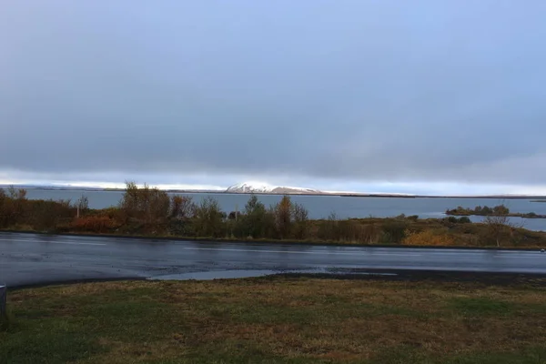 Дорога перед небольшой заснеженной горой — стоковое фото