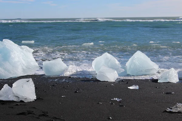 Gros morceaux d'iceburg sur la plage de sable noir en Islande — Photo