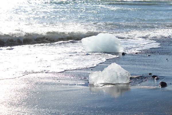 Gros morceaux d'iceburg sur la plage de sable noir en Islande — Photo