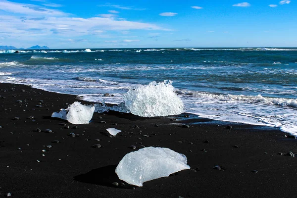 Velké kusy ledovce na černé písečné pláži na Islandu — Stock fotografie