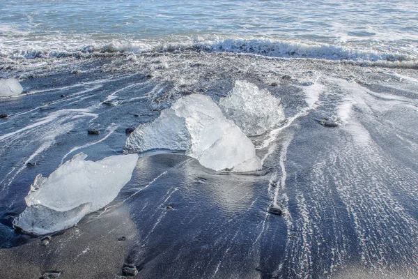 Duże kawałki lodowca na czarnej plaży piaskowej w Islandii — Zdjęcie stockowe