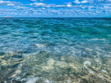 Turkuaz dalgalar sahile çarpıyor.