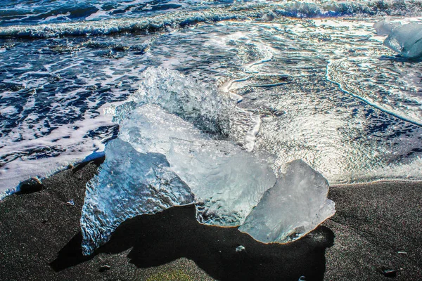 Большие куски айсберга на черном песчаном пляже в Исландии — стоковое фото