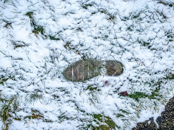 one footprint in the snow on ground