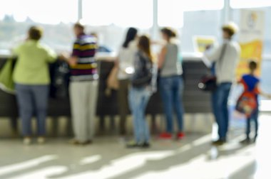 İnsanlar bir sırada kayıt için operatör bekler.