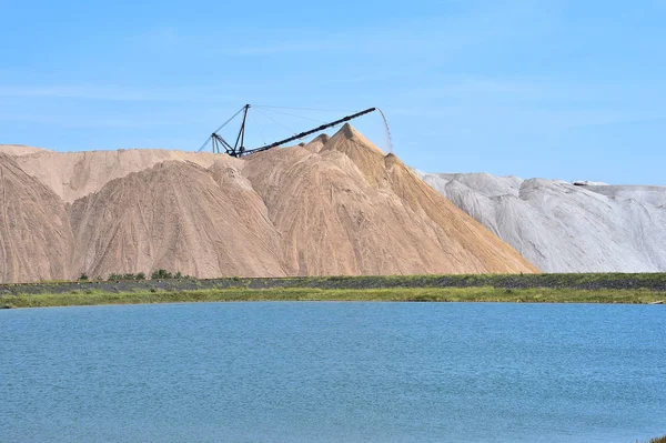 The salt-mine in the form of a hill with conveyor rocks. The foreground is an artificial pond — Stock Photo, Image