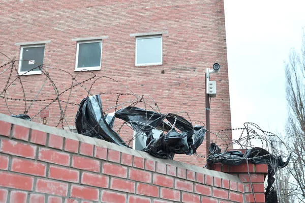 Videovigilancia de la cámara en el fondo del edificio montado en una pared de ladrillo, vallado con alambre de púas — Foto de Stock