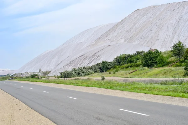 Asphalt road on the edge of the dumps of the mines of Belarus, the city of Soligorsk — Stock Photo, Image