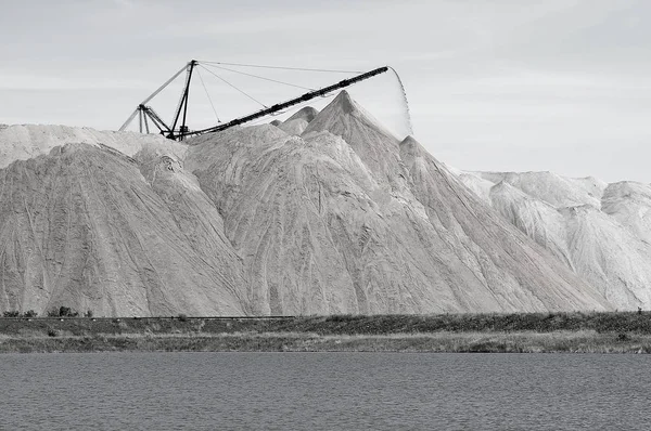 The salt-mine in the form of a hill with conveyor rocks. The foreground is an artificial pond — Stock Photo, Image