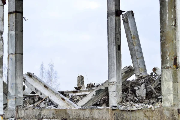 Remains of the destroyed industrial building. Large concrete piles continue to hold the body of the large concrete buildings, while others look at the sky. — Stock Photo, Image
