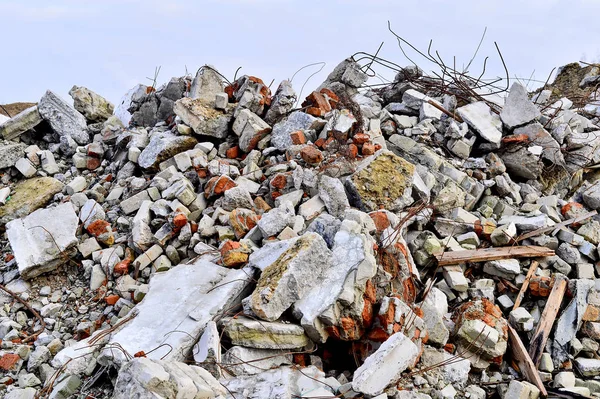 Batang baja mencuat dari tumpukan reruntuhan bata, batu dan puing-puing beton . — Stok Foto