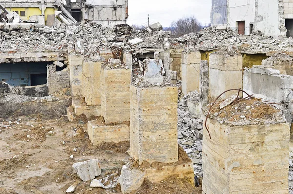 A powerful Foundation piles with protruding rebar on the background of a ruined industrial building. — Stock Photo, Image