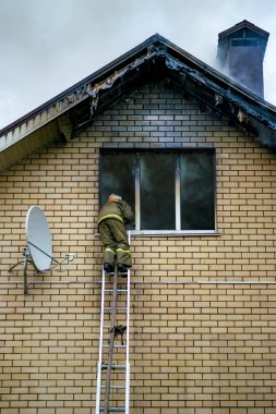 Böyle bir yanan bina yüksekliği uzantısı merdivenler ile bir itfaiyeci söndürür