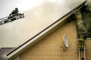 Böyle bir yanan bina yüksekliği uzantısı merdivenler ile bir itfaiyeci söndürür