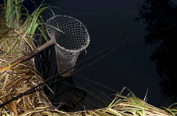 Vintage fishing net on the banks of the river at night. The symbol of fishing