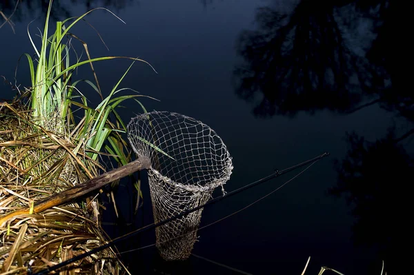 Vintage fishing net on the banks of the river at night. The symbol of fishing