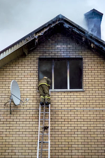 消防士を出す高さ繰出しはしごと燃えているビル — ストック写真