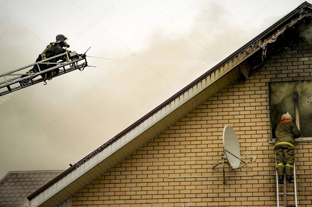 A firefighter puts out a burning building with height extension ladders.
