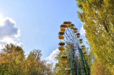 Autumn in Park. View of the Ferris wheel against the sky. Trees 