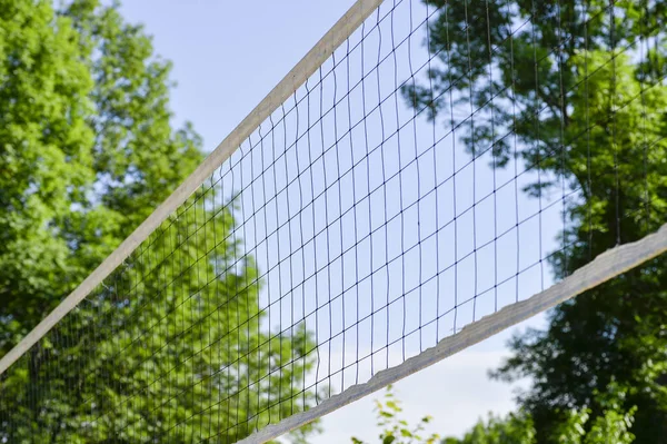 Volleyballnetz diagonal auf dem Hintergrund des Himmels und der Baumkronen. Hintergrund — Stockfoto