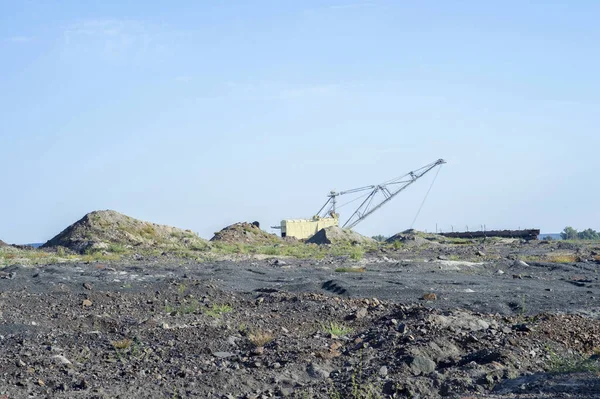 Una enorme excavadora lleva roca desde el tren descargado de la mina. El concepto de minería y problemas ambientales . — Foto de Stock