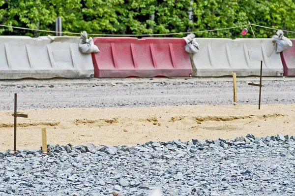 Byggande av vägen, staket vägkanten under läggningen av trottoaren. Bakgrund — Stockfoto