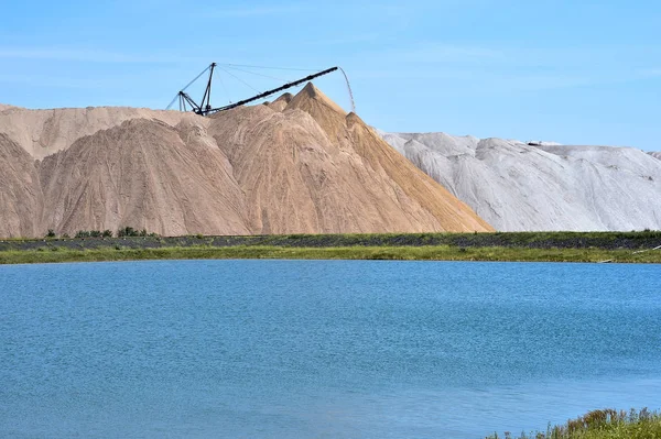 The salt-mine in the form of a hill with conveyor rocks. The foreground is an artificial pond — Stock Photo, Image