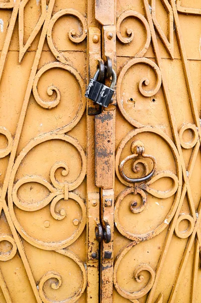 Parte da porta antiga com fechadura preta, ornamento de ferro fundido . — Fotografia de Stock