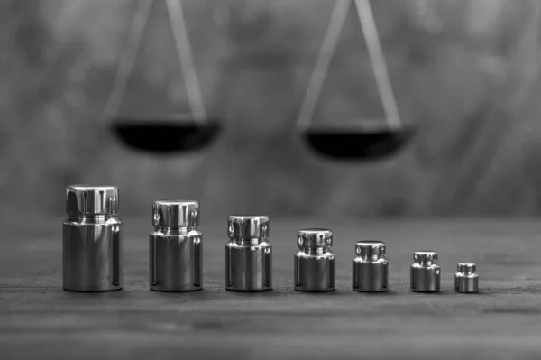 Arka planda çeşitli ağırlıklardan oluşan parlak metal ağırlıklar. Doğruluğu ölçme kavramı.