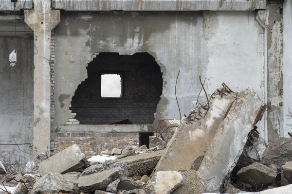 Restos da destruição de um grande edifício de concreto com um buraco na parede . — Fotografia de Stock