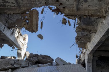 Destruction of buildings. A huge gap in the concrete slab with concrete fragments hanging on the rebar. Background