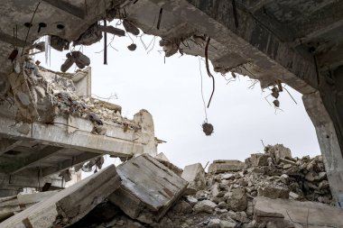 Destruction of buildings. A huge gap in the concrete slab with concrete fragments hanging on the rebar. Background