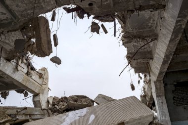 Destruction of buildings. A huge gap in the concrete slab with concrete fragments hanging on the rebar. Background
