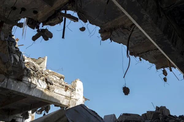 Destruição de edifícios. Uma enorme lacuna na laje de concreto com fragmentos de concreto pendurados na barra de vergalhões. Contexto — Fotografia de Stock