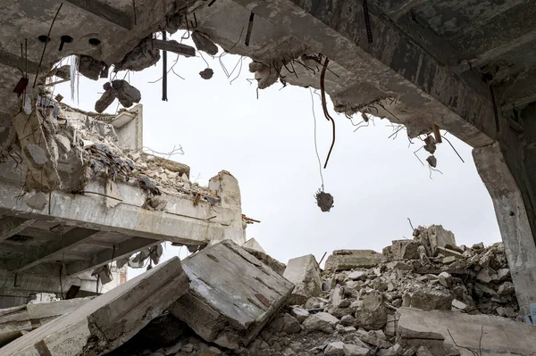 Destruição de edifícios. Uma enorme lacuna na laje de concreto com fragmentos de concreto pendurados na barra de vergalhões. Contexto — Fotografia de Stock