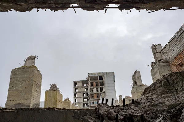 Vista através de uma lacuna na parede de concreto com vergalhões salientes sobre os restos de pilhas de concreto da Fundação . — Fotografia de Stock