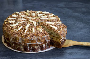 Gri arkaplanda bambu spatulası üzerine ayrı bir parçayla çikolatalı pasta..