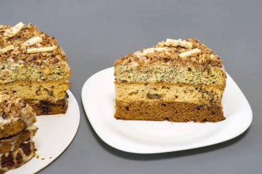 Gri arka planda beyaz bir tabakta ayrı bir parçayla çikolatalı pasta.